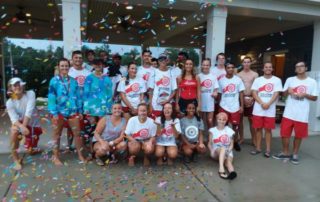 24 lifeguards posing for photo as confetti falls from above